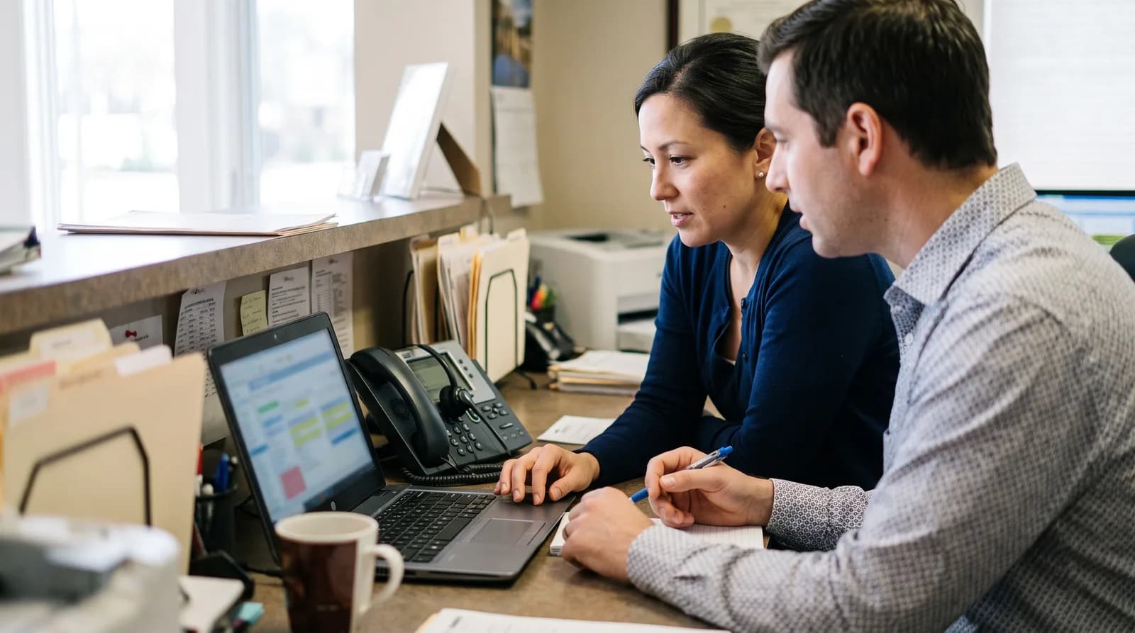 Dental office staff reviewing a call recording retention policy on a tablet at the front desk