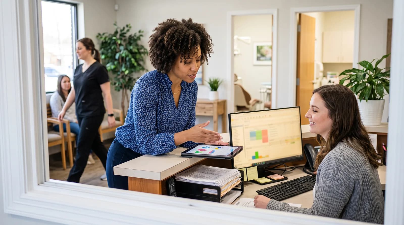 Dental office staff reviewing automated scheduling and billing dashboard on a computer, showing ROI gains for practice AI